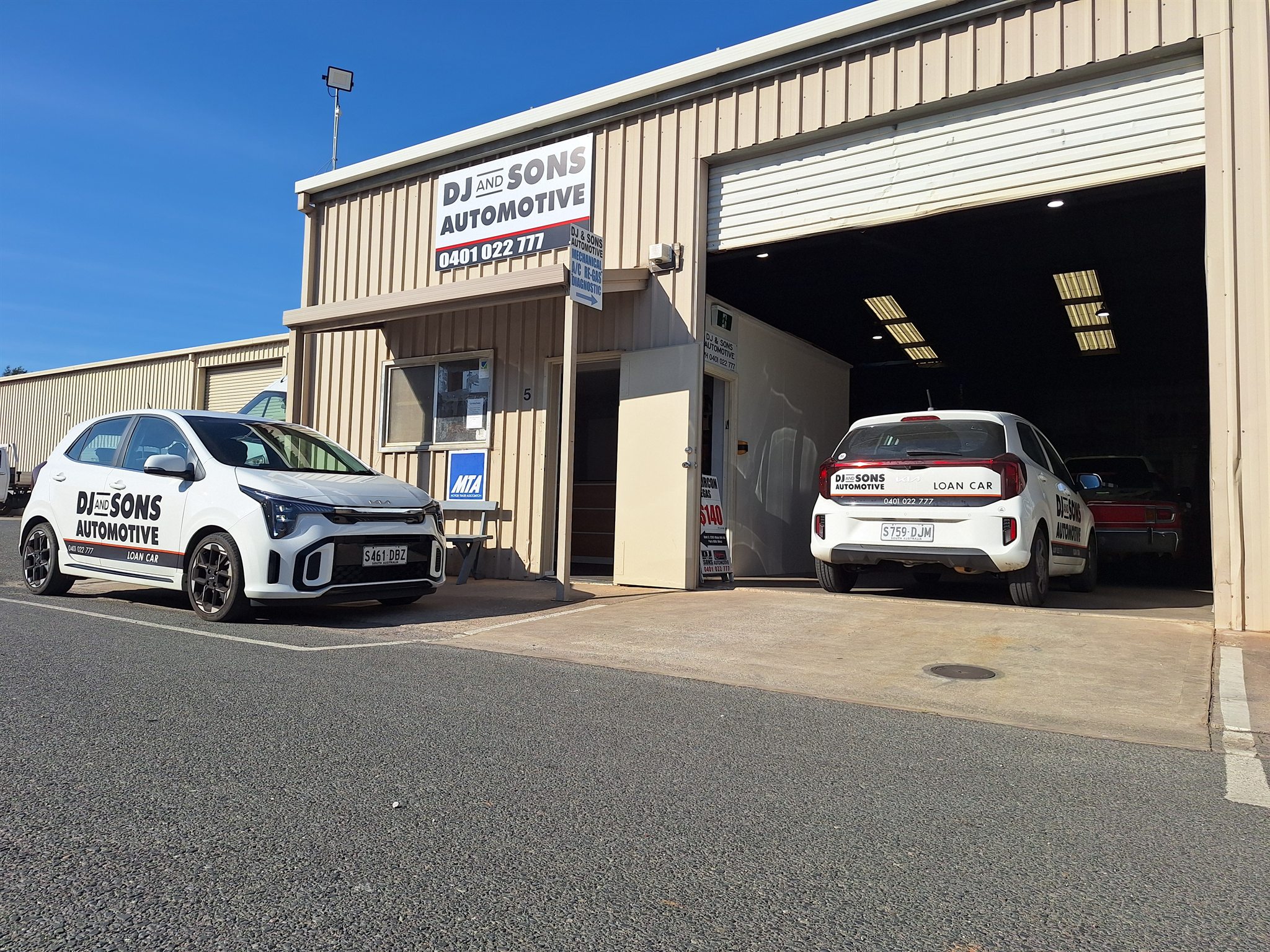 DJ and Sons Automotive workshop with two branded courtesy loan cars outside